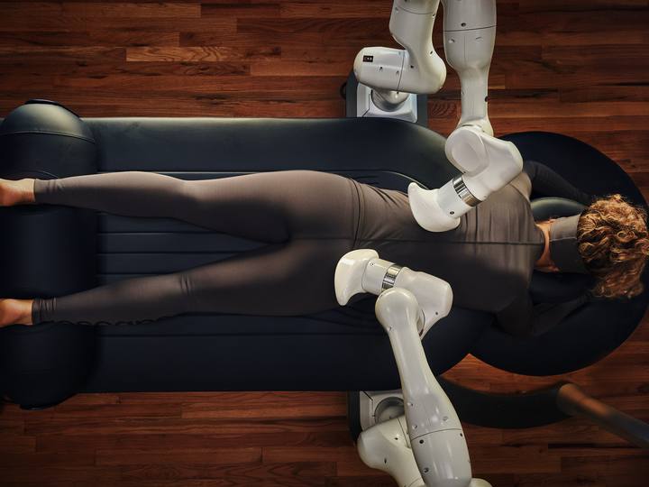 A Member lying face down while the two arms work the lower back.